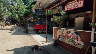 MINCA, COLOMBIA - CIRCA MARCH 2020: Kolombiya 'nın kuzeyindeki Karayip kıyısına yakın dağlardaki Minca kahve köyünde Coloful ahşap kafeler bulunan küçük asfaltsız sokak.