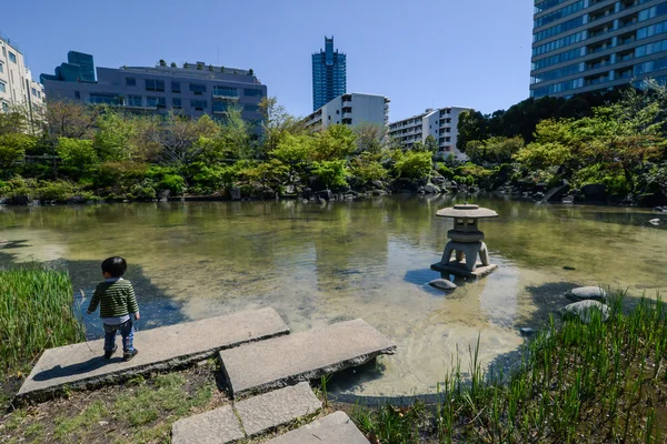 Een kind in de buurt van de vijver in het park in tokyo, japan — Stockfoto