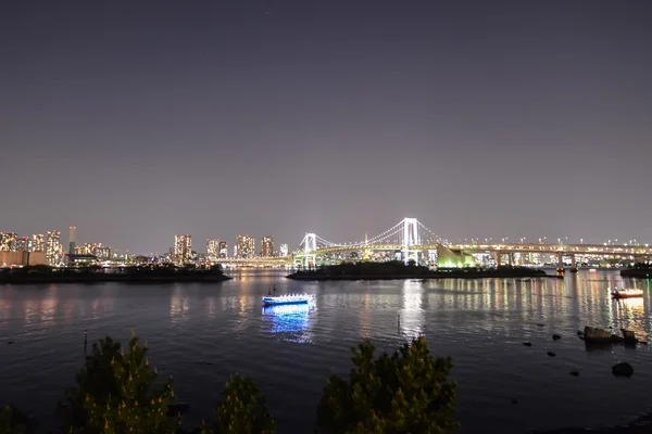 Glühende Boote, die in der Tokyobucht in der Nähe der Regenbogenbrücke schwimmen. Tokyo, Japan — Stockfoto