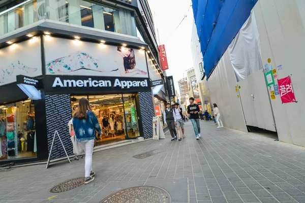 Gente caminando cerca de la tienda American Apparel en la zona comercial Myung Dong en Seúl — Foto de Stock