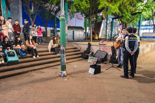 Polis bir sokak müzisyeni geceleri Seul konuşmak. — Stok fotoğraf