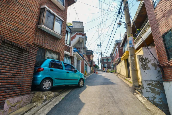 Um carro pequeno brilhante estacionado na rua estreita no distrito de Itaewon-dong em Seul — Fotografia de Stock