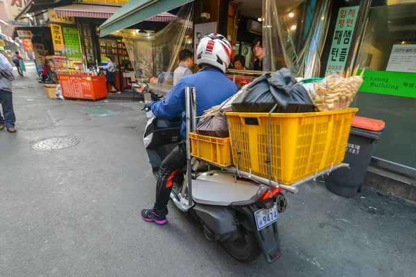 Um homem em uma bicicleta com enorme carga nas costas área Dongdaemun em Seul — Fotografia de Stock