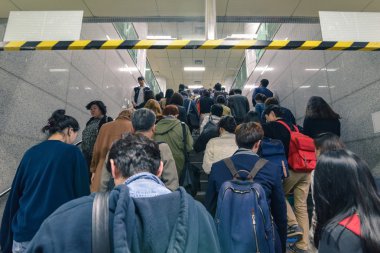 Seul 'de bir saat içinde metro istasyonundan yürüyen bir kalabalık.