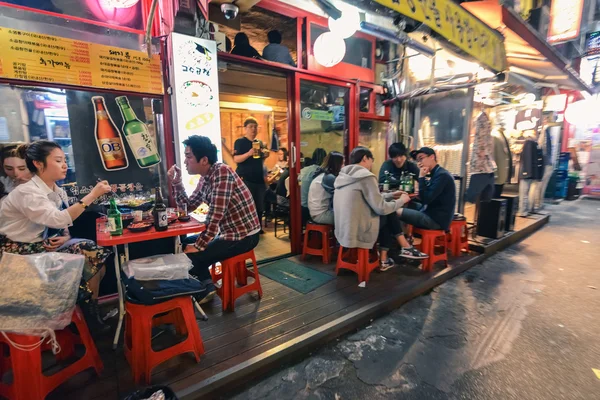 Seoul, Kore, Hungdae bölgesinde akşamları sokak café'de yeme insanlar — Stok fotoğraf