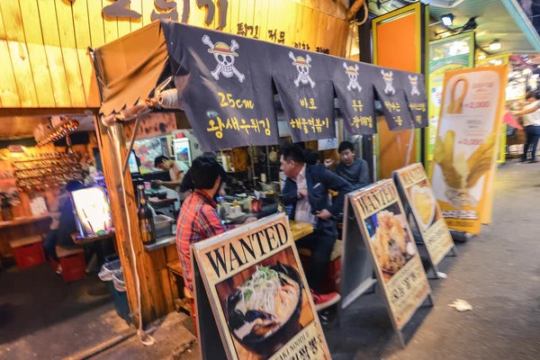 Молодые люди в уличном кафе в районе Хундэ в Сеуле, Корея — стоковое фото