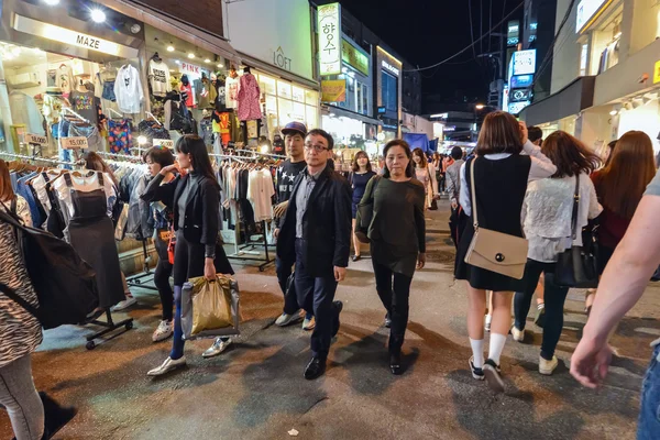 Jeunes marchant dans la soirée parmi les magasins locaux dans le quartier Hungdae à Séoul, Corée — Photo