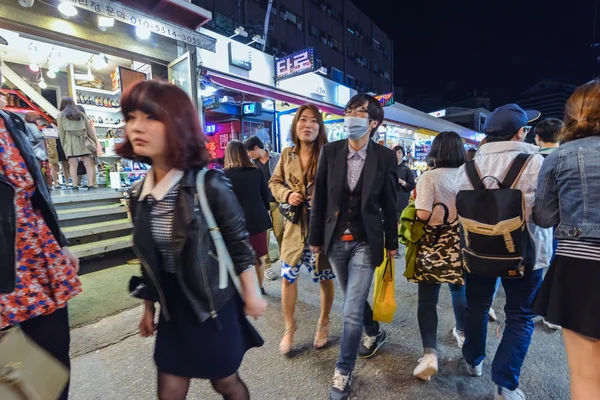 夜には、韓国のソウルでの Hungdae 地区を歩く若い人たち — ストック写真