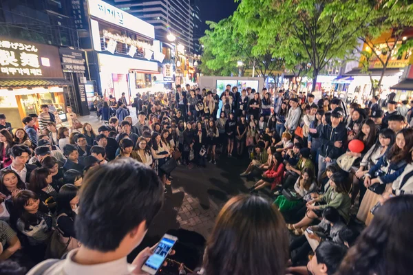 Une foule de jeunes a encerclé un musicien de rue dans le quartier Hungdae à Séoul, en Corée — Photo