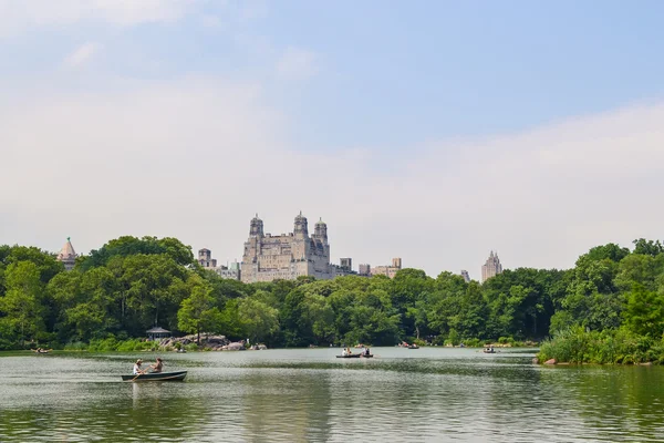 New York, USA - ca. Juni 2011: Menschen fahren Boote auf dem Teich zwischen Bäumen im Central Park, New York City, USA — Stockfoto