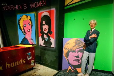 NEW YORK, CIRCA 2011 - Andy Warhol's wax figure with his pictures in Madame Tussaud's museum in New York clipart