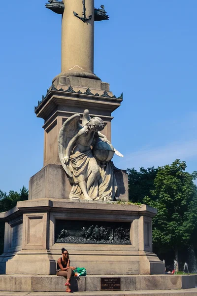 NEW YORK, CIRCA 2014 - A girl sits on foundation of The statue of Columbus by Gaetano Russo in the middle of Columbus Circle with blue sky on the background In New York City, NY, USA — Stok fotoğraf