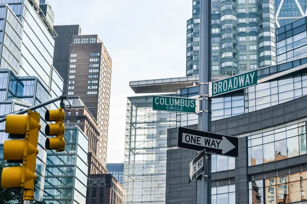 NEW YORK, CIRCA 2014 - Road signs of Broadway and Columbus with a skyscrapers at the background In New York City, NY, USA — Stok fotoğraf