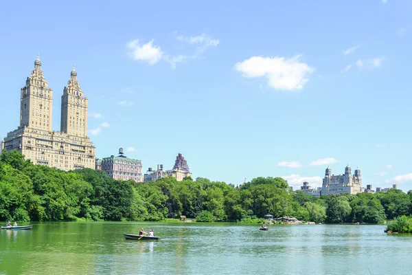 New York, USA - ca. Juni 2011: Menschen fahren Boote auf dem Teich zwischen Bäumen im Central Park, New York City, USA — Stockfoto