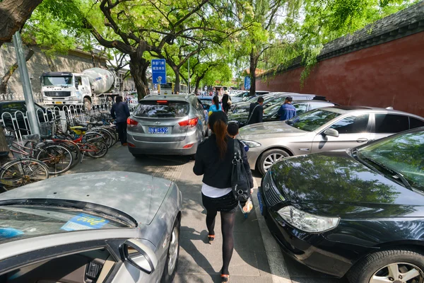 Beijing, china - circa arpil 2014. Frauen gehen zwischen Autos auf der Straße in beijing, china ca. April 2014. — Stockfoto