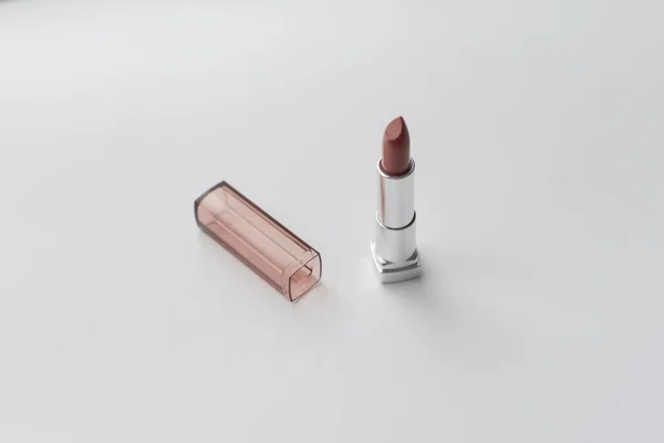 Brand new nude lipstick on the white table. — Stock Photo, Image