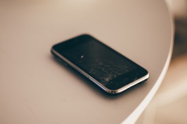 Moskova - 2015 yaklaşık: içinde kırık parçaları ile eski bir iphone ekran beyaz yüzey.