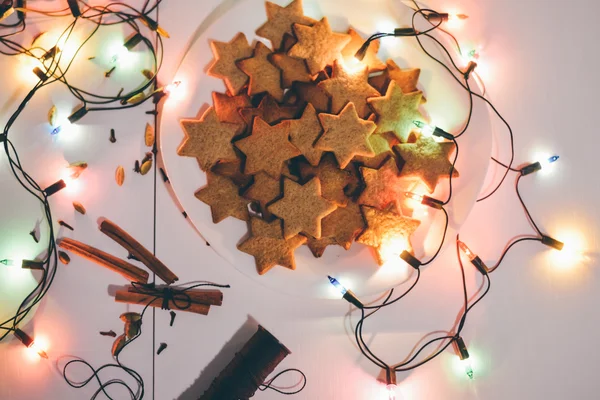 シナモンスティックとクリスマス ・ イヴのお祝いライトとテーブルの上の星の形でモスクワ - 2016 年 1 月 5 日: クリスマスのジンジャー クッキー. — ストック写真