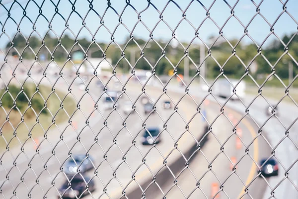 Vue d'une autoroute à travers une clôture métallique . — Photo