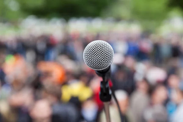 Mikrofon w fokus przeciwko niewyraźne publiczności. Protest. — Zdjęcie stockowe