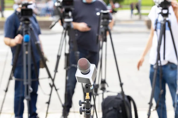 記者会見でのマイク 背景のぼやけたカメラマン — ストック写真
