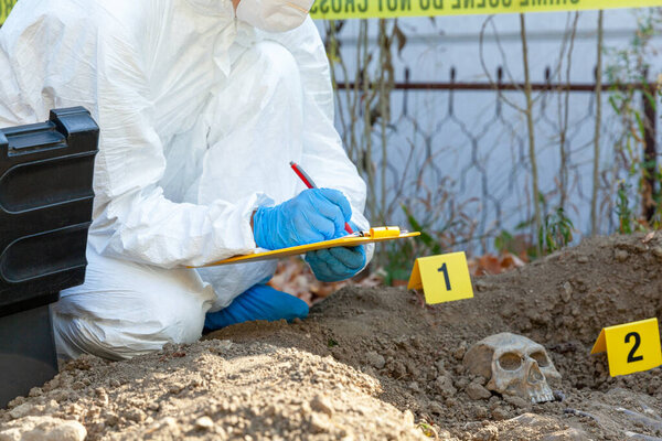 Расследование места преступления. Судебный эксперт, работающий над идентификацией человеческих останков.
