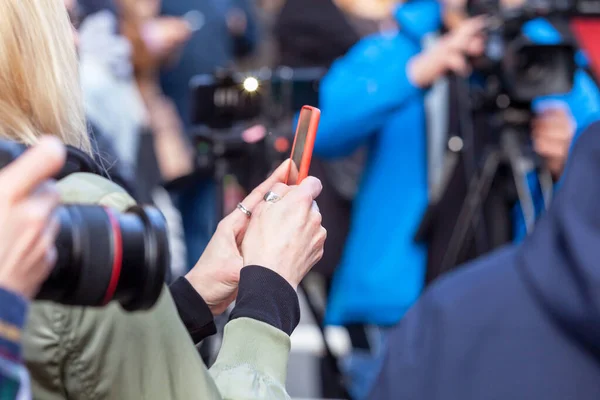 Press or news conference, mobile journalist filming media event with a smartphone