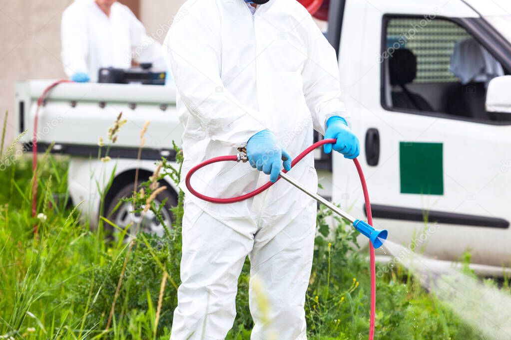 Pest control worker spraying insecticides or pesticides outdoor