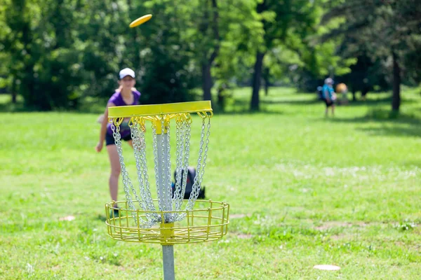 若い女性は 自然の中で飛んでディスクゴルフスポーツゲームをプレイ — ストック写真