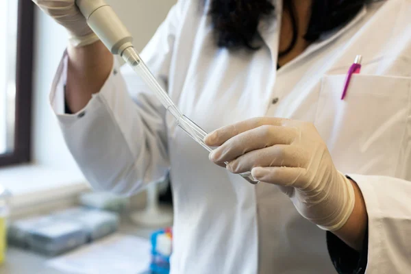 Cientista em tubo de ensaio de enchimento de laboratório com pipeta — Fotografia de Stock