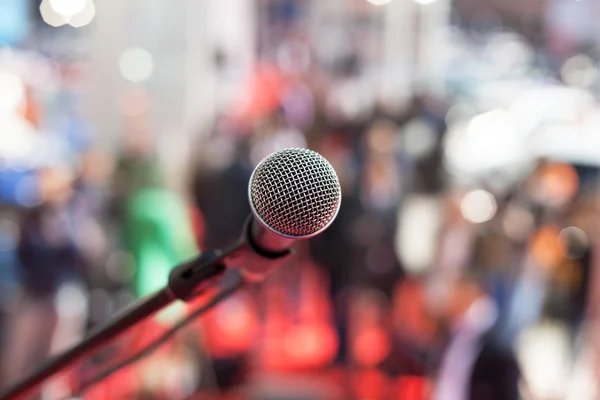 Microfone em foco contra o público turvo — Fotografia de Stock