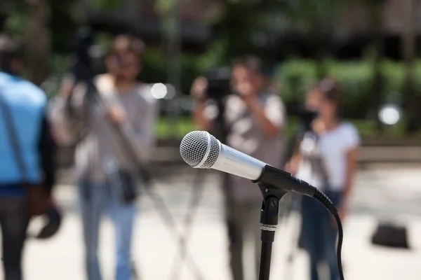 Микрофон в фокусе против размытого оператора — стоковое фото