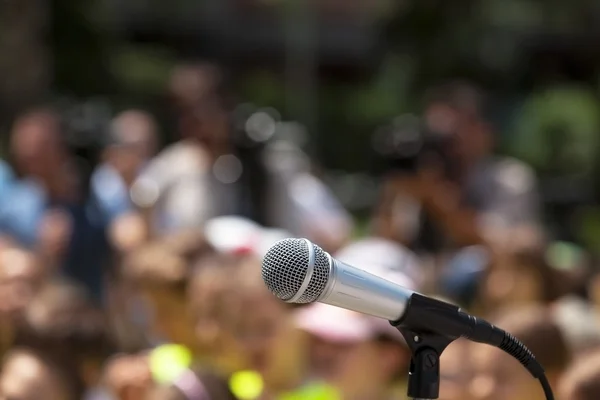 Mikrofon w centrum uwagi przed rozmytą publicznością — Zdjęcie stockowe