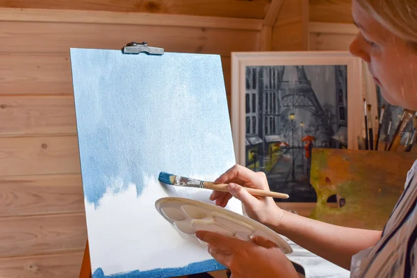 Dziewczyna artysta maluje obraz na płótnie w domu farbami olejnymi w domu. — Zdjęcie stockowe