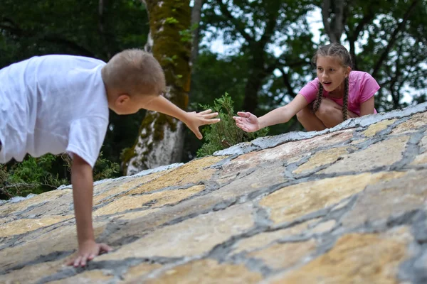 Vriendschap voor kinderen, hulp bij problemen, broer en zus beklimmen berg — Stockfoto