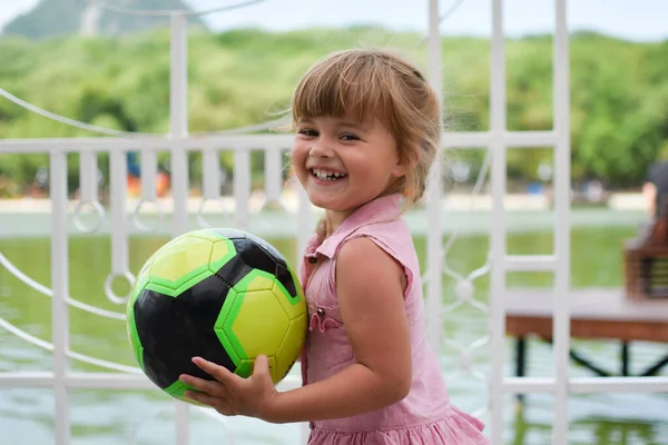 Gadis kecil Kaukasia cantik dengan bola besar di lapangan bermain. — Stok Foto