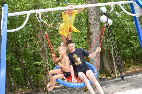 Funny kids swing on a big swing together, laughing kids on the playground, — Stock Photo, Image