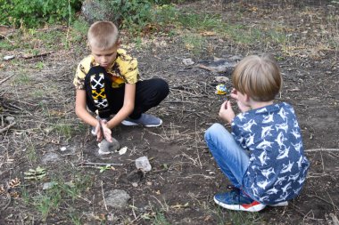 Küçük çocuklar ormanda tek başlarına ateş yakıyorlar..