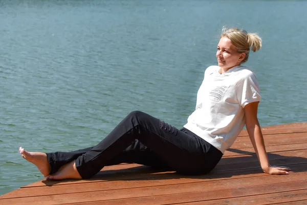 Mujer joven descansando en la orilla, relajante recreación al aire libre. un momento de calma — Foto de Stock