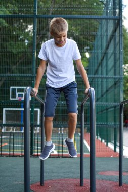 Çocuk spor yapıyor açık hava spor sahasında..