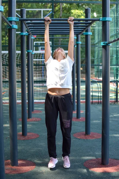 woman doing physical exercise in a public park in summer outdoor,
