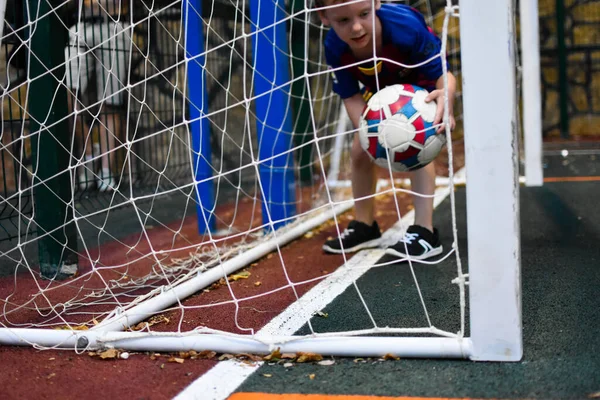 少年は屋外競技場で父親とサッカーをしています. — ストック写真