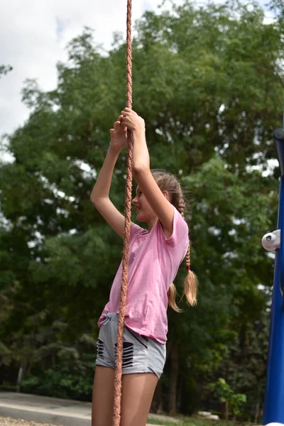 Девочка-подросток занимается спортом на улице на детской площадке. — стоковое фото