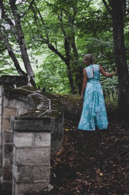 Ormanda tek başına yürüyen güzel bir kadın, uzun açık renk elbiseli bir kadın...