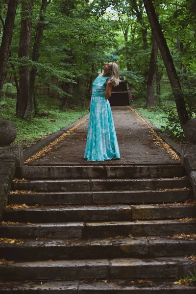 Bella signora cammina nella foresta da sola, una donna in un abito lungo luce i — Foto Stock