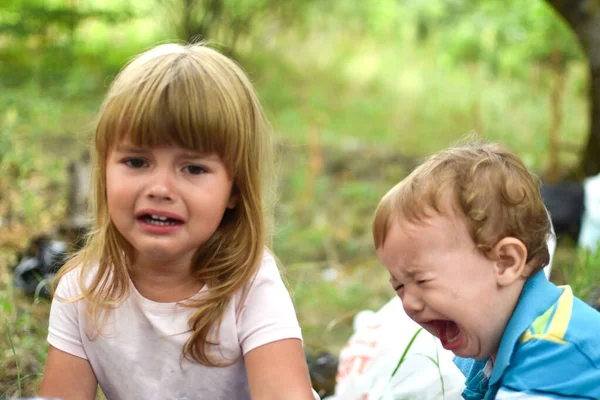 two little crying baby girls outdoor. upset girls sisters