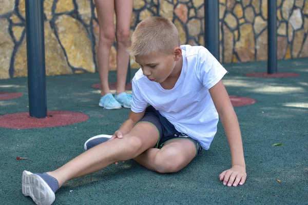 Anak laki-laki memukul di gym luar, anak terluka anggota tubuh di taman bermain — Stok Foto