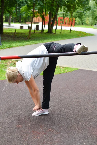 Młoda piękna aktywna kobieta robi ćwiczenia sportowe na świeżym powietrzu rano. — Zdjęcie stockowe