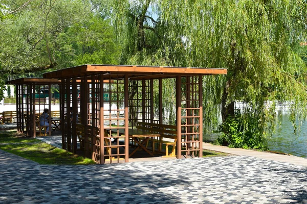 wooden terrace in a park on the lake, wooden gazebo for a picnic in the forest,