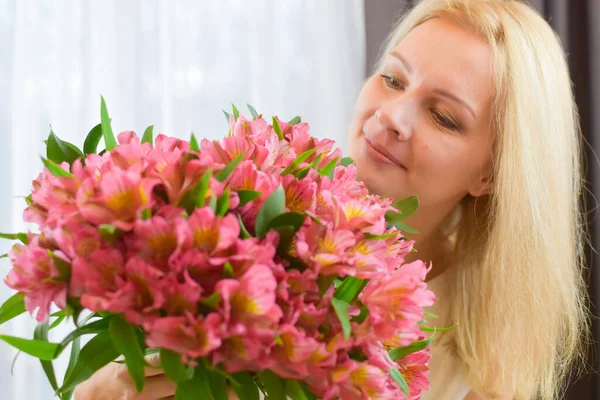 Mooie jonge vrouw met roze verse bloemen. bloemenlevering — Stockfoto